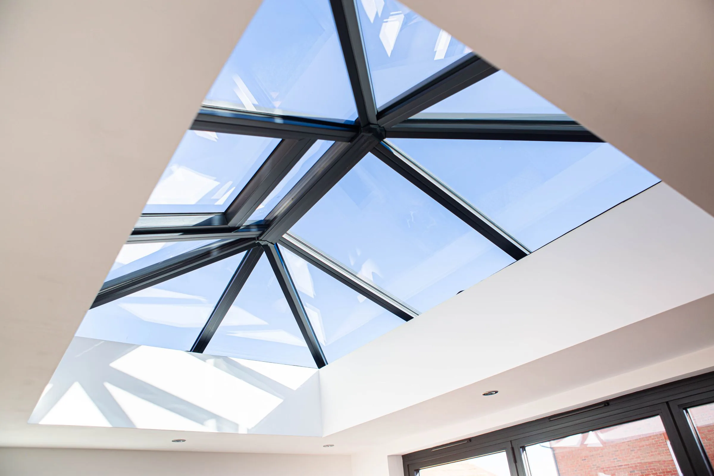 A roof lantern set into the plastered ceiling of a WarmerRoof insulated conservatory roof, seen from inside the room.