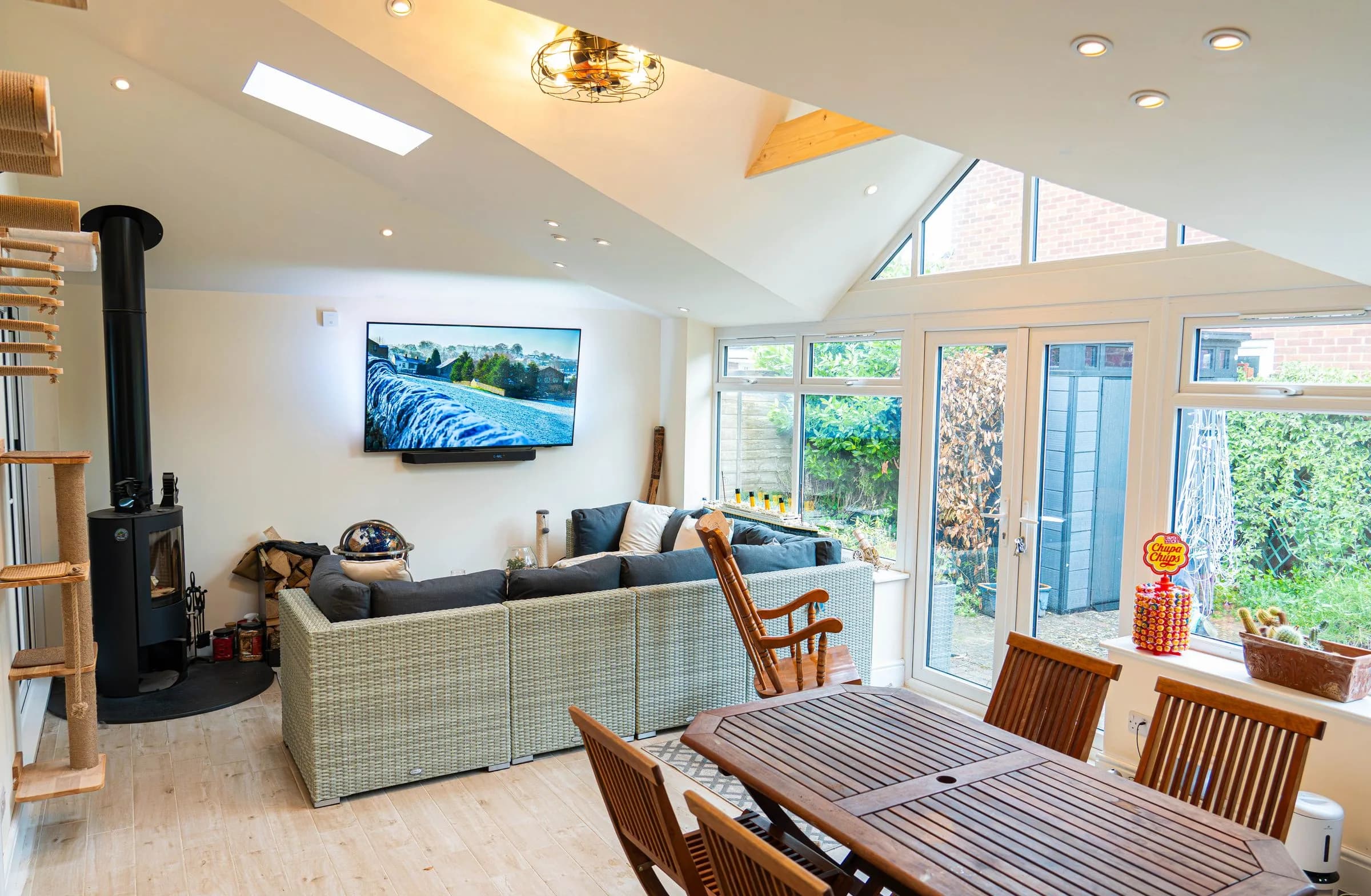 An open plan living and dining room under the vaulted plastered ceiling of a WarmerRoof insulated conservatory roof.